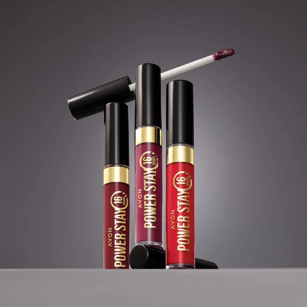 Três unidades do Power Stay Batom Líquido Matte 16h da Avon em tons de vinho, rosa e vermelho, com aplicador aberto, destaque entre os produtos Avon mais procurados no blog Belle Stelle